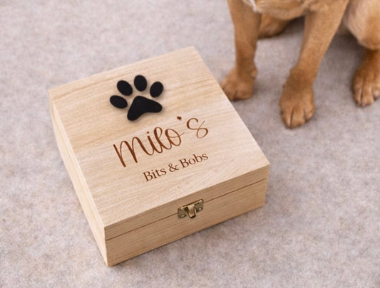 Wooden box with 'milo's Bits & Bobs' and a paw print design, with a dog in the background.