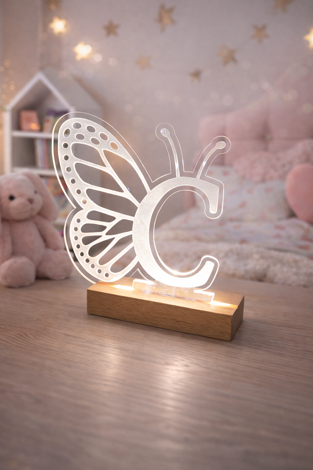 Butterfly-shaped night light on a wooden base in a cozy room with soft lighting.