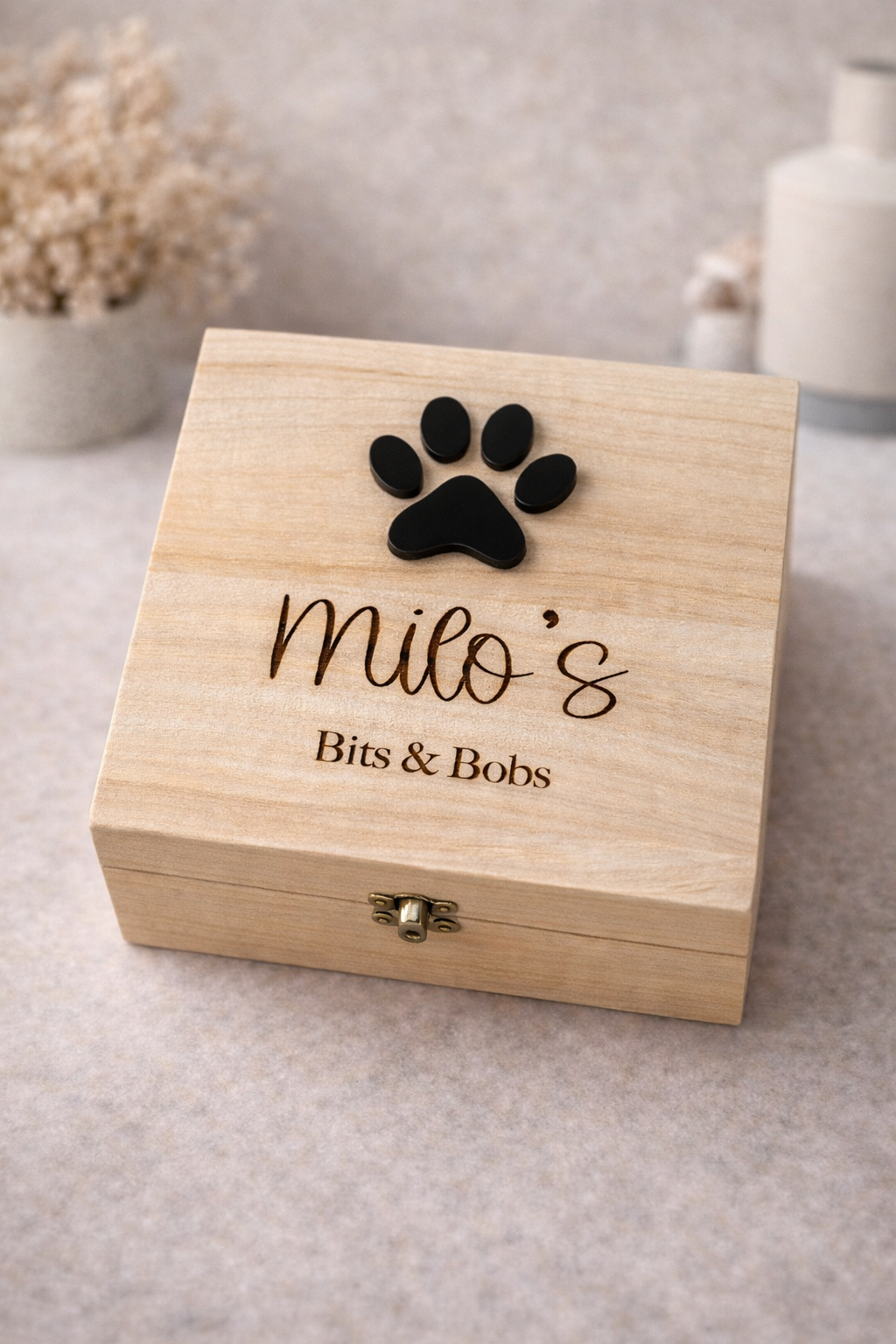 Wooden box with a paw print and engraved text on a neutral background
