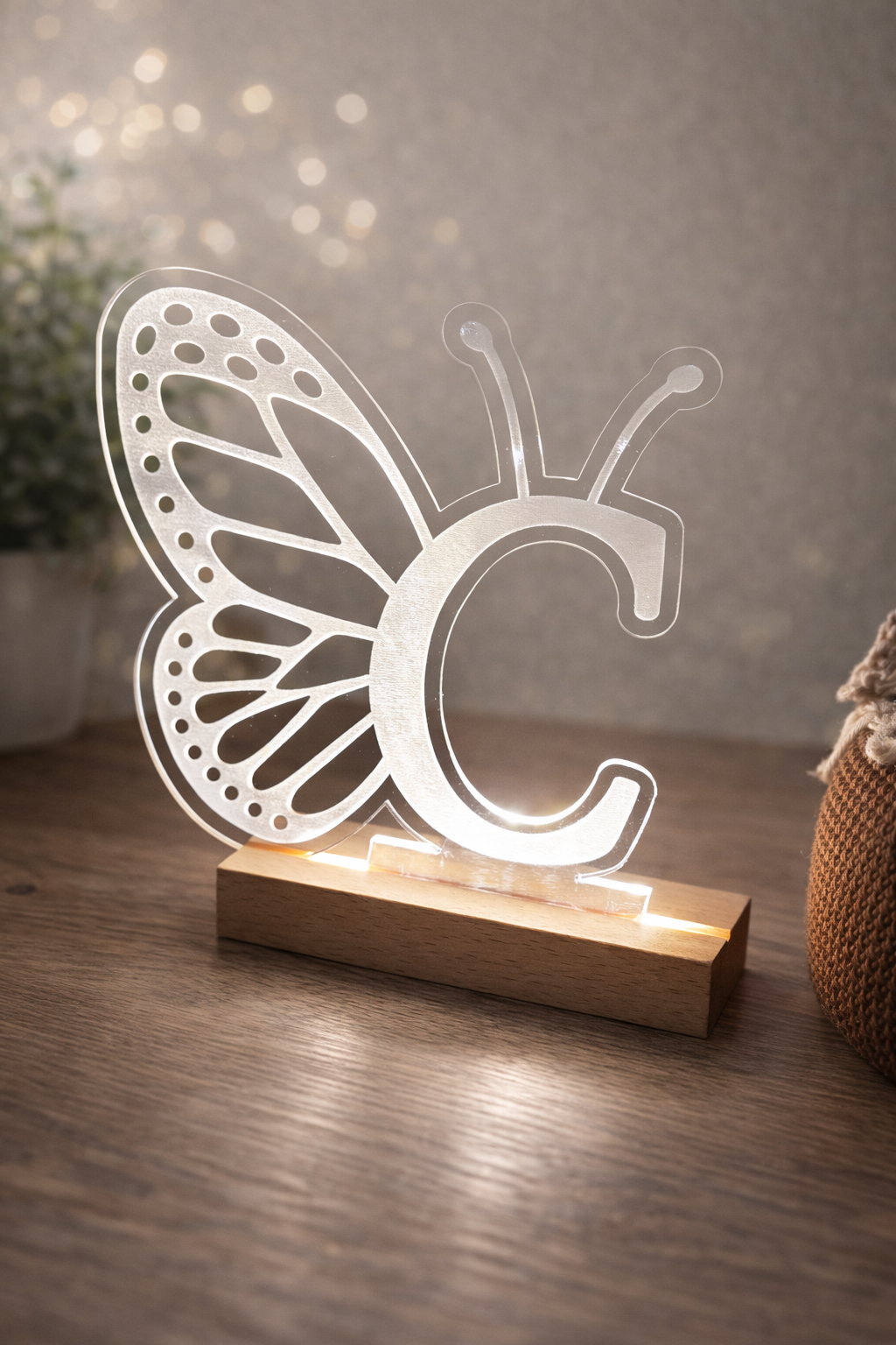 Butterfly-shaped night light with wooden base on a wooden surface