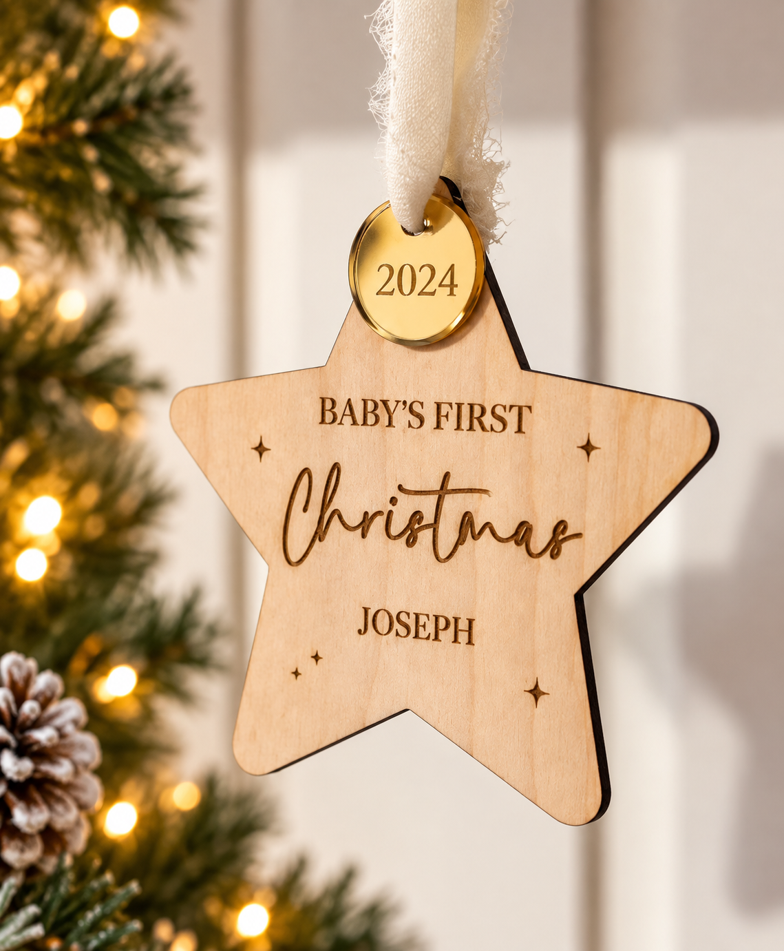 Personalised wooden baby's first Christmas decoration hanging beside a Christmas tree